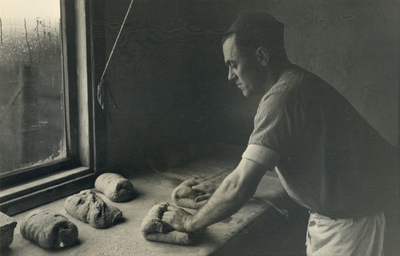 827327 Afbeelding van een medewerker van bakkerij J.W.A. Mulder (Dorpstraat C8) te Harmelen, tijdens het kneden van het deeg.